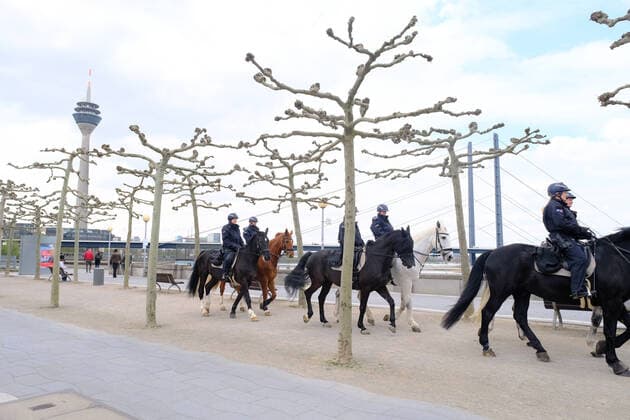 Dusseldorf 17 04 2021 Rhine bank promenade Rhine tower television tower Covid Corona lockdown mask obligation masks emergency brake shutdown infection protection law control old town logo warning fine police police horses police rider equestrian squadron horses Dusseldorf North Rhine Westphalia Germany