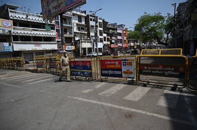 April 18, 2021, Allahabad, Uttar Pradesh, India: Prayagraj: A Policeman walk past barricade on first day of weekly lockdown during COVID-19 spread in Prayagraj on Sunday, April 18, 2021. Allahabad India - ZUMAv115 20210418_zap_v115_009 Copyright: xPrabhatxKumarxVermax