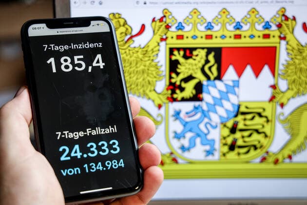 Coronavirus in Germany Covid 19 Dashboard of the Robert Koch Institute DEU, Germany, Bavaria, 18 04 2021 The 7-day incidence for the state Cases last 7 days 100 000 PE is displayed on an iPhone, with the state coat of arms in the background.