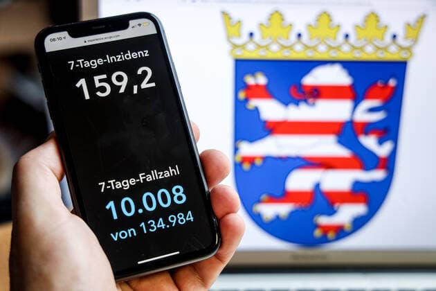 Coronavirus in Germany Covid 19 Dashboard of the Robert Koch Institute DEU, Germany, Hesse, 18 04 2021 The 7-day incidence for the state Cases last 7 days 100 000 PE is displayed on an iPhone, with the state coat of arms in the background.
