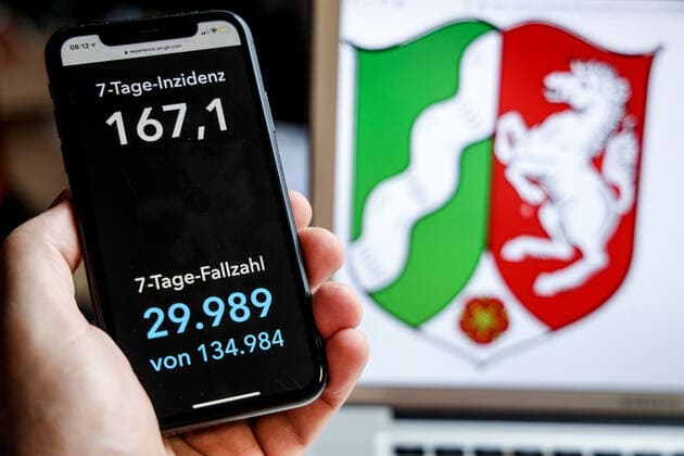 Coronavirus in Germany Covid 19 Dashboard of the Robert Koch Institute DEU, Germany, North Rhine Westphalia, 18 04 2021 The 7-day incidence for the state Cases last 7 days 100 000 PE is displayed on an iPhone, with the state coat of arms in the background.