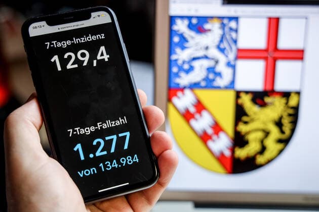 Coronavirus in Germany Covid 19 Dashboard of the Robert Koch Institute DEU, Germany, Saarland, 18 04 2021 The 7-day incidence for the state Cases last 7 days 100 000 PE is displayed on an iPhone, with the state coat of arms in the background.