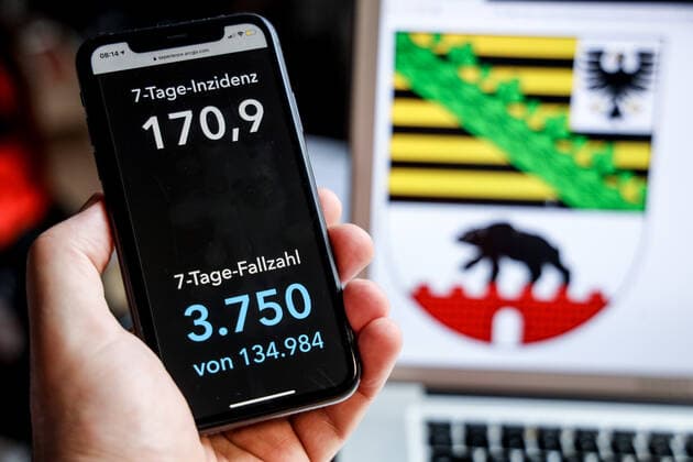 Coronavirus in Germany Covid 19 Dashboard of the Robert Koch Institute DEU, Germany, Saxony Anhalt, 18 04 2021 The 7-day incidence for the state Cases last 7 days 100 000 p.e. is displayed on an iPhone, with the state coat of arms in the background