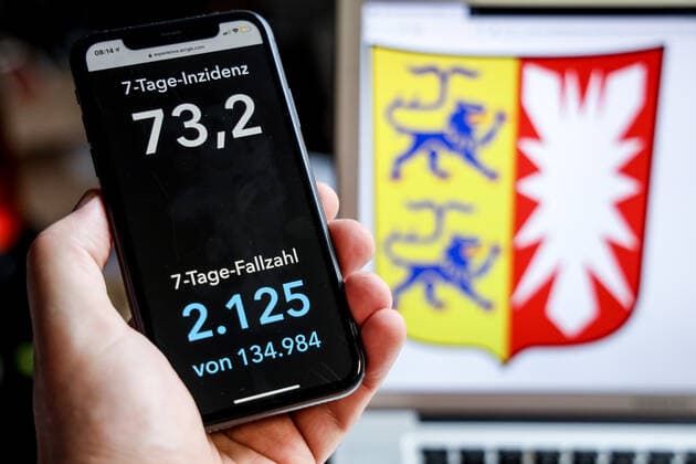 Coronavirus in Germany Covid 19 Dashboard of the Robert Koch Institute DEU, Germany, Schleswig Holstein, 18 04 2021 The 7-day incidence for the state Cases last 7 days 100 000 PE is displayed on an iPhone, with the state coat of arms in the background.