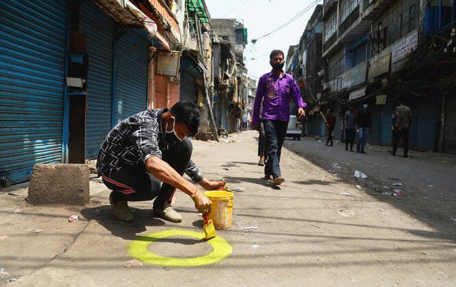 News Bilder des Tages April 18, 2021, New Delhi, India: A man wearing mask makes social distance marks for buyers in front of closed shops at Sadar Bazar wholesale market during the weekend lockdown imposed by the State government to curb the spike of coronavirus (Covid-19) cases. .Only essential services will be exempted from the lockdown, India reported 264,500 new Covid-19 infection cases, 1,501 deaths and 138,423 discharges in last 24 hours. New Delhi India - ZUMAs197 20210418_zaa_s197_062 Copyright: xNaveenxSharmax