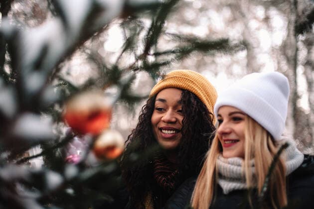 Diversity, Weihnachten Happy female friends decorating Christmas tree outdoors CR_DMBE210422-676722-01 ,model released, Symbolfoto