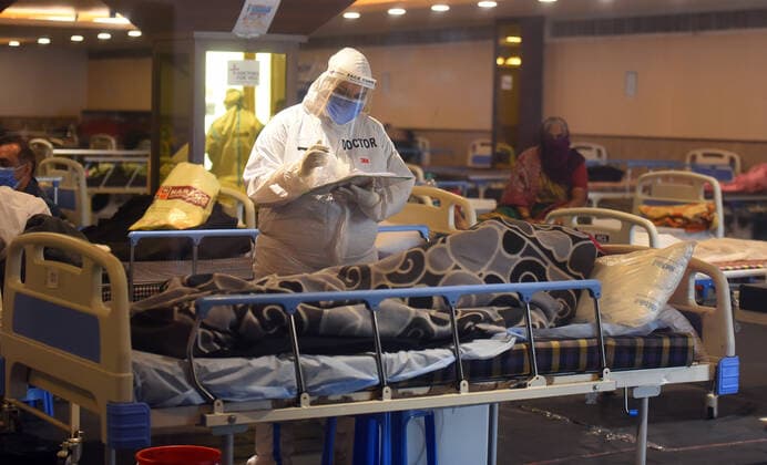 Coronavirus in Indien, Eindrücke aus Neu-Delhi NEW DELHI, INDIA APRIL 23: Medical staff in PPE attending to a person in the temporary Covid-19 care centre attached to LNJP Hospital, at Shehnai Banquet Hall, on April 23, 2021 in New Delhi, India. (Photo by Raj K Raj Hindustan Times ) Daily Life Amid Coronavirus Pandemic In India