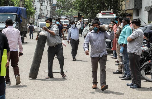 April 23, 2021, New Delhi, India: Family members of Covid-19 infected patients move with empty cylinders to refill outside the oxygen filling center in New Delhi..India is running out of oxygen during the second wave of Covid-19 pandemic. India has recorded 332,730 new Covid-19 cases in a single day and 2,263 deaths in the last one day. New Delhi India - ZUMAs197 20210423_zaa_s197_326 Copyright: xNaveenxSharmax