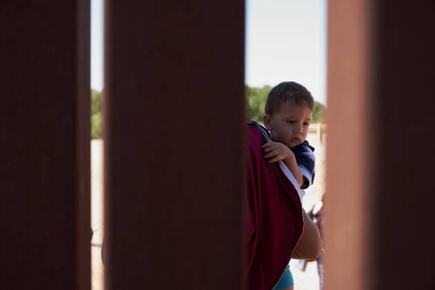 April 23, 2021, Yuma, Arizona, USA: A young child is seen through the US Border Wall with Mexico as asylum seeking migrants surrender to United States Border Patrol in Yuma, AZ. Yuma USA - ZUMAd211 20210423_zap_d211_001 Copyright: xAllisonxDinnerx