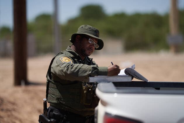 April 23, 2021, Yuma, Arizona, USA: A US Border Patrol agent writes up paper work for asylum seeking migrants who surrendered at the US Border Wall with Mexico in Yuma, AZ. Yuma USA - ZUMAd211 20210423_zap_d211_019 Copyright: xAllisonxDinnerx