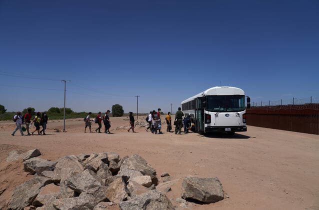 April 23, 2021, Yuma, Arizona, USA: Asylum seeking migrants board a bus for transport after surrendering to United States Border Patrol at the US Border Wall with Mexico in Yuma, AZ. Yuma USA - ZUMAd211 20210423_zap_d211_004 Copyright: xAllisonxDinnerx