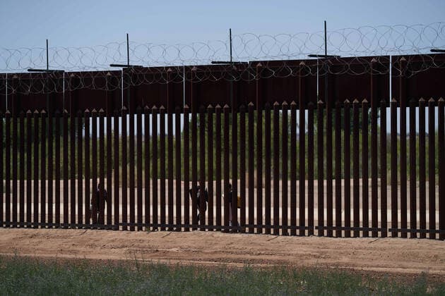 April 23, 2021, Yuma, Arizona, USA: Asylum seeking migrants are seen walking just before they surrender to United States Border Patrol at the US Border Wall with Mexico in Yuma, AZ. Yuma USA - ZUMAd211 20210423_zap_d211_028 Copyright: xAllisonxDinnerx