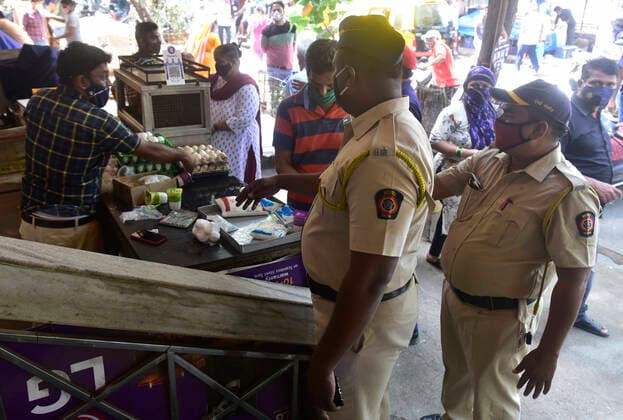 MUMBAI, INDIA - APRIl 23: Mumbai Police officials instruct vegetable vendors to shut their shops after the 11 am deadline during strict lockdown imposed by government at Naigaon vegetable market, on April 23, 2021 in Mumbai, India. (Photo by Anshuman Poyrekar Hindustan Times) Daily Life Amid Coronavirus Pandemic In India