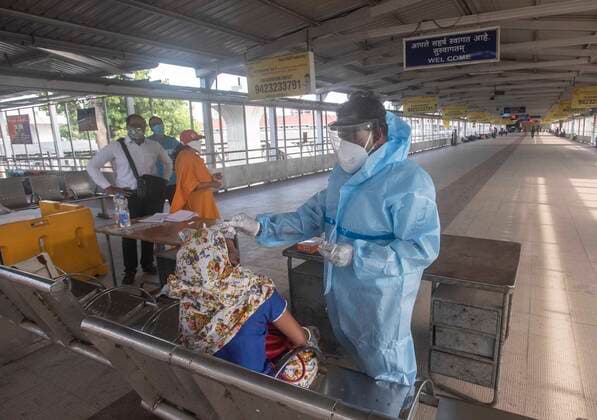 PUNE, INDIA - APRIl 23: A health worker in PPE kit conducts Covid-19 tests of a passenger as she arrives from other state at Pune railway station, on April 23, 2021 in Pune, India. (Photo by Pratham Gokhale Hindustan Times) Daily Life Amid Coronavirus Pandemic In India