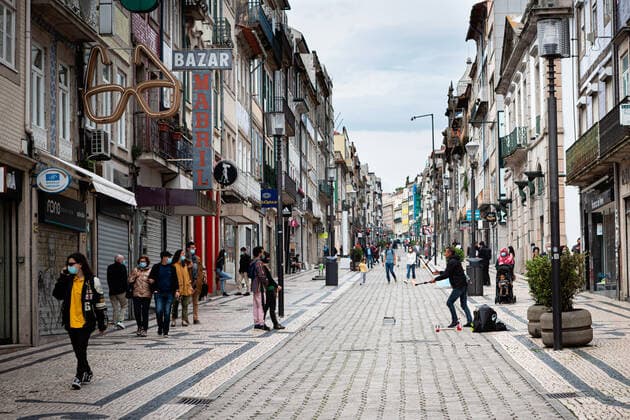 April 24, 2021, Porto, Portugal: People wearing face masks walk on the street..Portugal is at the 3rd stage of the deconfinement plan but stores, restaurants and coffee shops are still closed on the weekend during the afternoon. Porto Portugal - ZUMAs197 20210424_zaa_s197_215 Copyright: xTeresaxNunesx