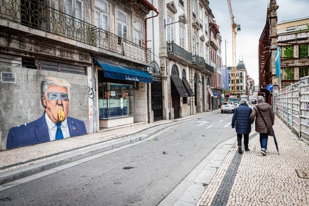 April 24, 2021, Porto, Portugal: Two people walk past a graffiti portraying Donald Trump..Portugal is at the 3rd stage of the deconfinement plan but stores, restaurants and coffee shops are still closed on the weekend during the afternoon. Porto Portugal - ZUMAs197 20210424_zaa_s197_225 Copyright: xTeresaxNunesx