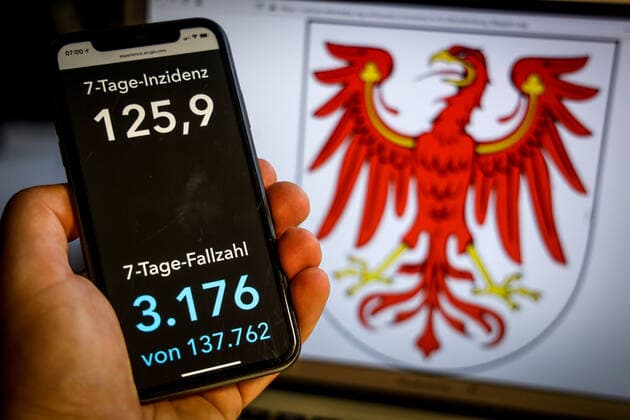 Coronavirus in Germany Covid 19 Dashboard of the Robert Koch Institute DEU, Germany, Brandenburg, 25 04 2021 The 7-day incidence for the state Cases last 7 days 100 000 PE is displayed on an iPhone, with the state coat of arms in the background.