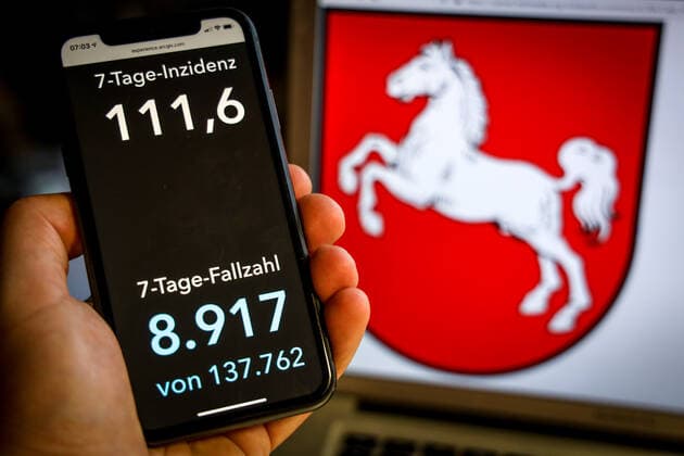 Coronavirus in Germany Covid 19 Dashboard of the Robert Koch Institute DEU, Germany, Lower Saxony, 25 04 2021 The 7-day incidence for the state Cases last 7 days 100 000 PE is displayed on an iPhone, with the state coat of arms in the background.