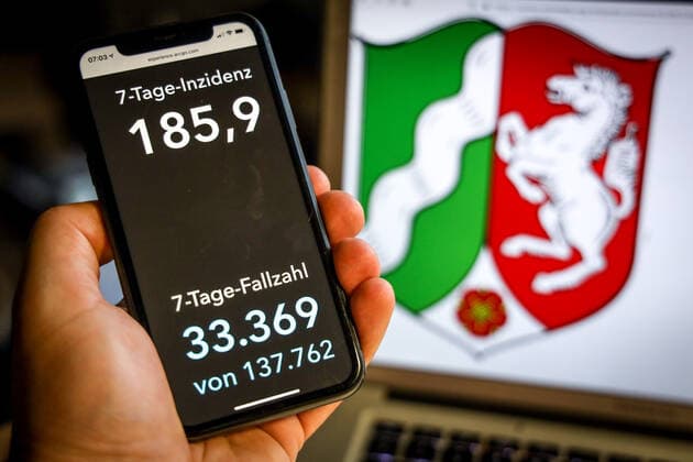 Coronavirus in Germany Covid 19 Dashboard of the Robert Koch Institute DEU, Germany, North Rhine Westphalia, 25 04 2021 The 7-day incidence for the state Cases last 7 days 100 000 PE is displayed on an iPhone, with the state coat of arms in the background.
