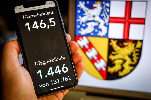 Coronavirus in Germany Covid 19 Dashboard of the Robert Koch Institute DEU, Germany, Saarland, 25 04 2021 The 7-day incidence for the state Cases last 7 days 100 000 PE is displayed on an iPhone, with the state coat of arms in the background.