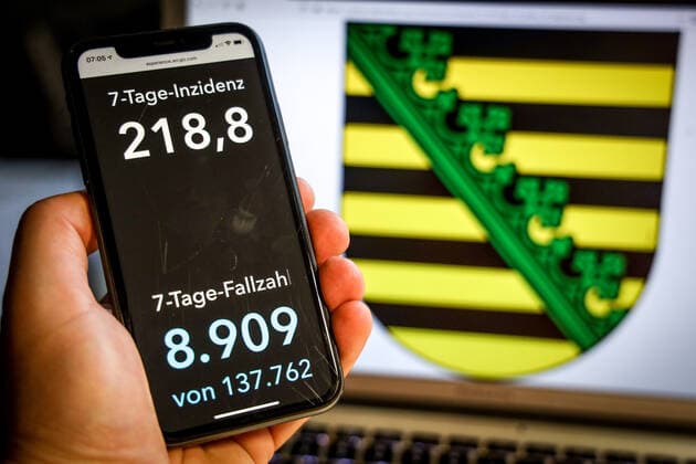 Coronavirus in Germany Covid 19 Dashboard of the Robert Koch Institute DEU, Germany, Saxony, 25 04 2021 The 7-day incidence for the state Cases last 7 days 100 000 PE is displayed on an iPhone, with the state coat of arms in the background.