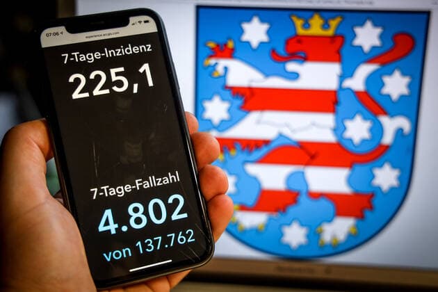 Coronavirus in Germany Covid 19 Dashboard of the Robert Koch Institute DEU, Germany, Thuringia, 25 04 2021 The 7-day incidence for the state Cases last 7 days 100 000 p.e. is displayed on an iPhone, with the state coat of arms in the background