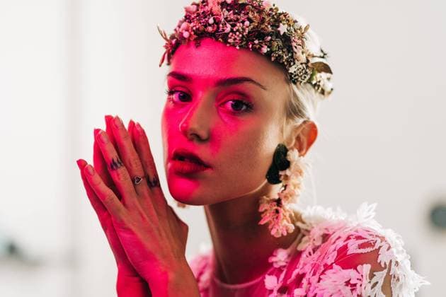 Elegant young female in white wedding gown with jewelry wreath looking at camera in studio with neon illumination Copyright: xJakexJakabx Model Released