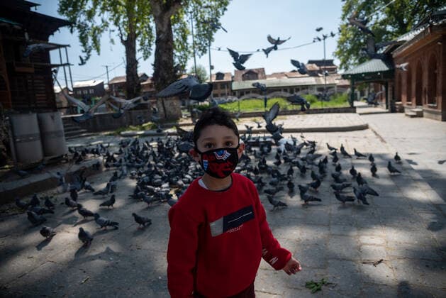 April 25, 2021, Srinagar, Jammu and Kashmir, India: A kid wearing a face mask looks on during a one day curfew to curb the spread of COVID-19 in Srinagar..India has reported 346,786 new cases of COVID-19 for the previous 24 hours, with 2,624 deaths, the world™s highest daily toll since the pandemic begun last year. Overall, nearly 190,000 people have died from COVID in the country, while more than 16.6 million have been infected. Srinagar India - ZUMAs197 20210425_zaa_s197_057 Copyright: xIdreesxAbbasx
