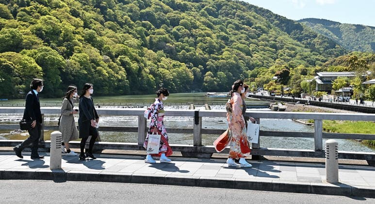 Pedestrians wearing face masks walk at Togetsukyo Bridge in Kyoto, Japan on Sunday, April 25, 2021. Tokyo,Osaka, Kyoto and Hyogo prefectures entered a new state of emergency for COVID-19 on April 25 through May 11.  TKP2021042516 KEIZOxMORI