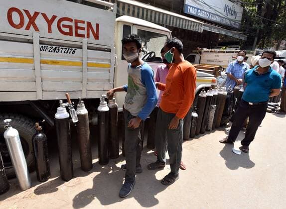 NEW DELHI, INDIA - APRIL 26: Family members of patients stand with empty oxygen cylinders outside the oxygen filling center at Bhogal on April 26, 2021 in New Delhi, India. (Photo By Sonu Mehta Hindustan Times) India Faces Oxygen Crisis As Covid-19 Cases Mount