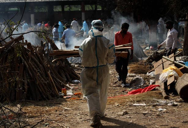 April 26, 2021, New Delhi, India: A family member carries wood to prepares funeral pyres for their relative who died from COVID-19 disease before cremation at Ghazipur cremation ground in New Delhi..In India the highest single-day spike in coronavirus infection. The report recorded 352,991 new Covid-19 cases and 2,812 deaths in the last 24 hours amid an oxygen crisis. New Delhi India - ZUMAs197 20210426_zaa_s197_116 Copyright: xNaveenxSharmax