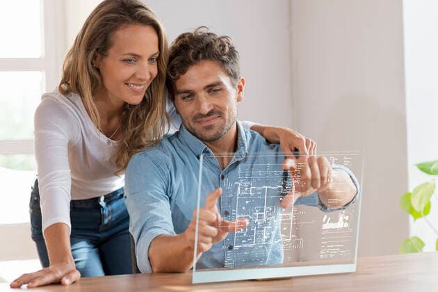 Mid adult couple looking at floor plan over transparent screen at home model released Symbolfoto property released SBOF03696