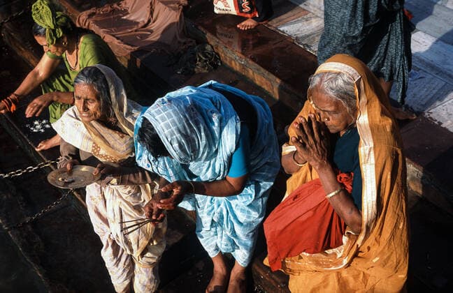 13 03 2010, Haridwar, Uttarakhand, India, Asia Female pilgrims in their colorful traditional robes pray during the Hindu religious festival Purna Kumbh Mela at the Har Ki Pauri Ghat on the banks of the holy Ganges river.