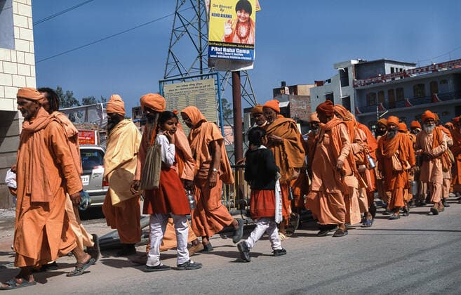 13 03 2010, Haridwar, Uttarakhand, India, Asia A group of male pilgrims in orange robes on their way to Har Ki Pauri Ghat on the banks of the holy Ganges during the Hindu religious festival Purna Kumbh Mela.