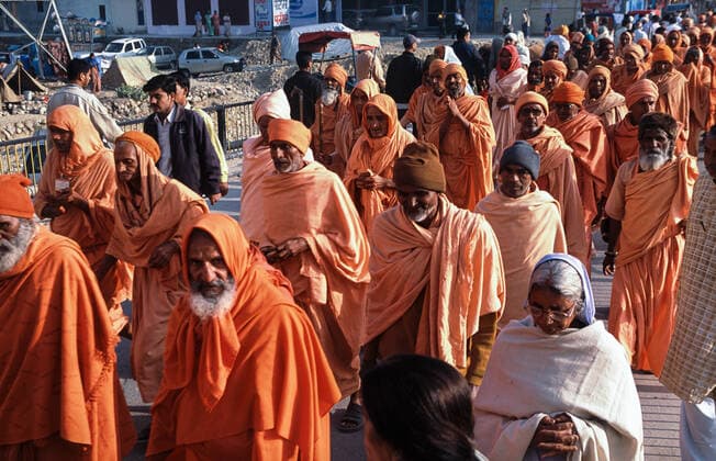 13 03 2010, Haridwar, Uttarakhand, India, Asia A group of male pilgrims in orange robes on their way to Har Ki Pauri Ghat on the banks of the holy Ganges during the Hindu religious festival Purna Kumbh Mela.