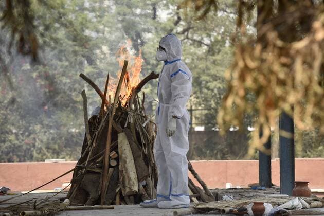NOIDA, INDIA - APRIL 27: A relative of a Covid-19 victim performing the last rites at Sector 94 crematorium on April 27, 2021 in Noida, India. (Photo by Sunil Ghosh Hindustan Times) Covid Death Toll Continues To Rise In India
