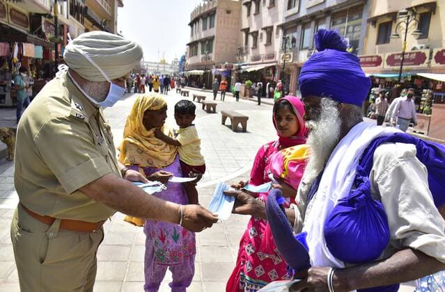 AMRITSAR, INDIA - APRIL 27: Police personnel distributing face masks during an awareness campaign against the spread of Covid-19 at Heritage street on April 27, 2021 in Amritsar, India. (Photo by Sameer Sehgal Hindustan Times) NGO Distributes Facemasks During An Awareness Campaign Against The Spread Of Covid-19 In Amritsar
