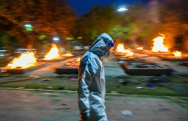NEW DELHI, INDIA - APRIL 28: Multiple funeral pyres of people who died of Covid-19 burning simultaneously at Sarai kale khan crematorium on April 28, 2021 in New Delhi, India. India, in the last 24 hours, recorded 3,60,960 fresh Covid-19 cases and 3,293 deaths, which is the highest in the country so far. With today?s numbers, the total number of coronavirus cases rose to 1,79,97,267 and the number of fatalities reached 2,01,187. At present, there are 29,78,709 active cases in India and as many as 1,48,17,371 people have recovered. (Photo by Amal KS Hindustan Times) Covid Death Toll Continues To Rise In India