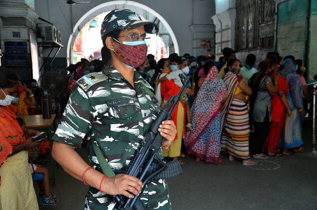India: Eight phase of West Bengal state elections A woman paramilitary soldier stands guard as voters wait outside at a polling station during the eight phase of West Bengal state elections in Kolkata in India. India Copyright: SanjayxPurkait