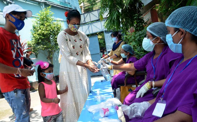 India: Eight phase of West Bengal state elections Volunteers check body temperature and sanitized of voters and distribute gloves at a polling station during the eight phase of West Bengal state elections in Kolkata, India. India Copyright: SanjayxPurkait