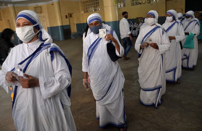 India: Eight phase of West Bengal state elections Catholic nuns from the Missionaries of Charity, the global order of nuns founded by Saint Mother Teresa, wear protective face masks as they wait in a line to cast their vote outside a polling station during the eight and final phase of West Bengal state election in Kolkata, India. India Copyright: SanjayxPurkait