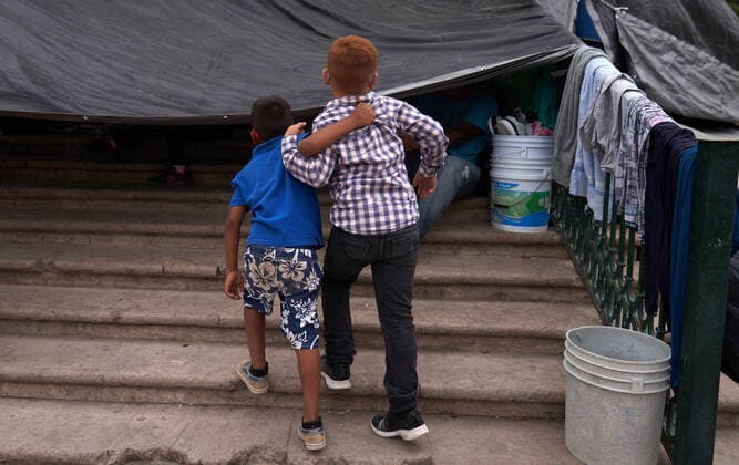 April 29, 2021, Reynosa, Mexico: Two kids walk with their arms around each other. Asylum seeking migrants from Central America are living on the street in Reynosa, Mexico while they wait for President Biden to open the US border for them to try to cross. Reynosa Mexico - ZUMAd211 20210429_zap_d211_003 Copyright: xAllisonxDinnerx
