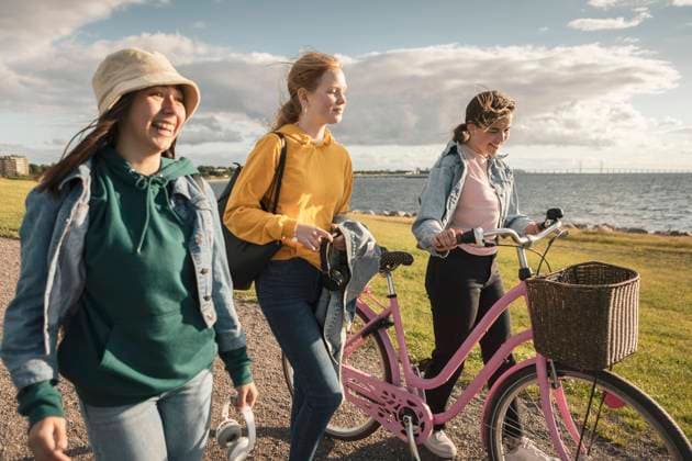 IMAGO Creative: Jahreszeit Frühling, Picknick IMAGO Creative: Landleben - Alfresco, Draußen IMAGO Creative: Digitale Welt, Verzicht auf Technologie Happy female friends with bicycle walking at lakeshore against cloudy sky Sweden, Malmo, model released Copyright: xKentarooxTrymanx , MA86361