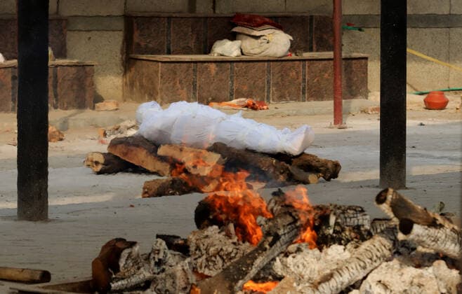 April 30, 2021, New Delhi, India: (EDITORS NOTE: Image depicts death).A body of a Covid-19 victim lies on a funeral pyre during the mass cremation at Dwarka crematorium..The ongoing vaccination drive will open for 18-45 age group from May 01, 2021. India has recorded 386,452 new coronavirus infection cases and 3,498 death in the last 24 hours. New Delhi India - ZUMAs197 20210430_zaa_s197_091 Copyright: xNaveenxSharmax
