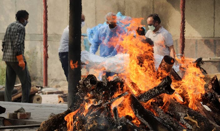 April 30, 2021, New Delhi, India: (EDITORS NOTE: Image depicts death).Grieving family members wearing Personal Protective Equipment (PPE) carry the body of a covid19 victim during the mass cremation at Dwarka crematorium..The ongoing vaccination drive will open for 18-45 age group from May 01, 2021. India has recorded 386,452 new coronavirus infection cases and 3,498 death in the last 24 hours. New Delhi India - ZUMAs197 20210430_zaa_s197_092 Copyright: xNaveenxSharmax