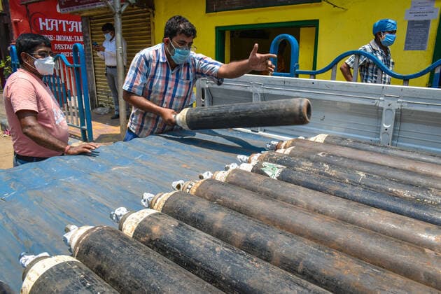 India: Oxygen crisis during covid-19 pandemic in Kolkata Employees of an oxygen refilling shop unloading oxygen cylinder from a small truck during the oxygen crisis situation due to the spread of corona virus (Covid-19) in Kolkata. Kolkata West Bengal India Copyright: SudiptaxDas