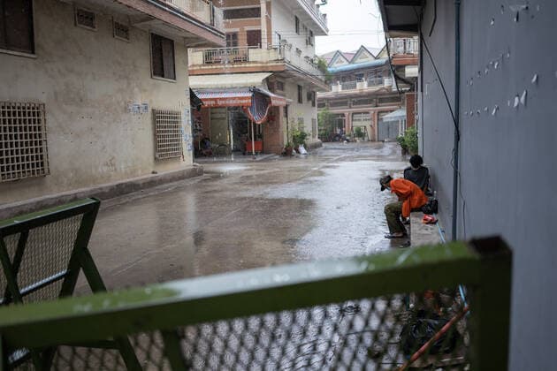 April 23, 2021, Phnom Penh, Cambodia: Residents take shelter from the rain during the lockdown..Phnom Penh remains in lockdown as Cambodia takes drastic measures to reduce the spread of its worst COVID-19 outbreak to date. The lockdown has forced many out of work, including factory workers and market vendors, leaving the cities™ poorest residents struggling or unable to afford basic necessities. Phnom Penh Cambodia - ZUMAs197 20210423_zaa_s197_465 Copyright: xAndyxBallx