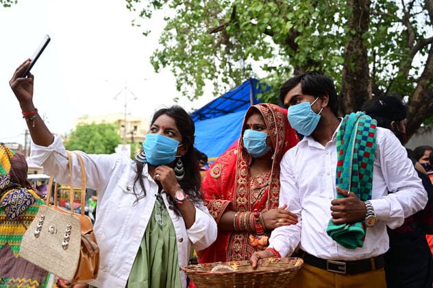 May 3, 2021, Prayagraj, Uttar Pradesh, India: Prayagraj: A Newly married couple take selfie with family member while arrived to perform prayer outside closed Alopi Devi Temple during government imposed weekend Lockdown in Prayagraj on Monday, May 03, 2021. Prayagraj India - ZUMAv115 20210503_zap_v115_033 Copyright: xPrabhatxKumarxVermax