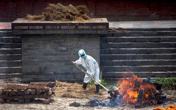 (210503) -- KATHMANDU, May 3, 2021 -- A worker cremates victims who died from COVID-19 at Pashupatinath Temple crematorium in Kathmandu, Nepal, May 3, 2021. (Photo by Xinhua) NEPAL-KATHMANDU-COVID-19 VICTIMS-CREMATION SulavxShrestha 