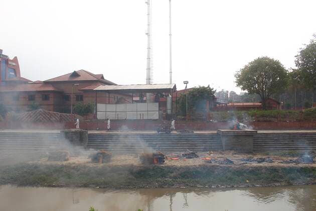 Workers from the crematorium light funeral pyres over the bodies of Covid-19 victim Workers from the crematorium light funeral pyres over the bodies of COVID-19 victims along the banks of the Bagmati river, owing to the second wave of the coronavirus pandemic on the fifth-day of a government imposed lockdown. Nepal Copyright: DipendraxDhungana
